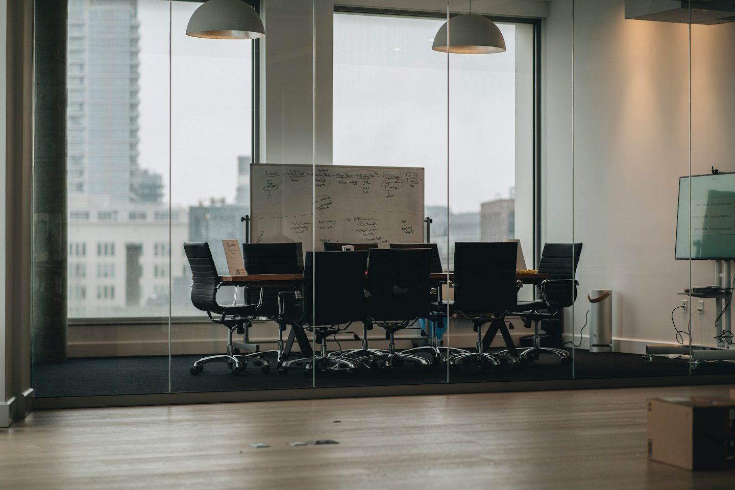 Empty conference room with a large wooden table and city view.