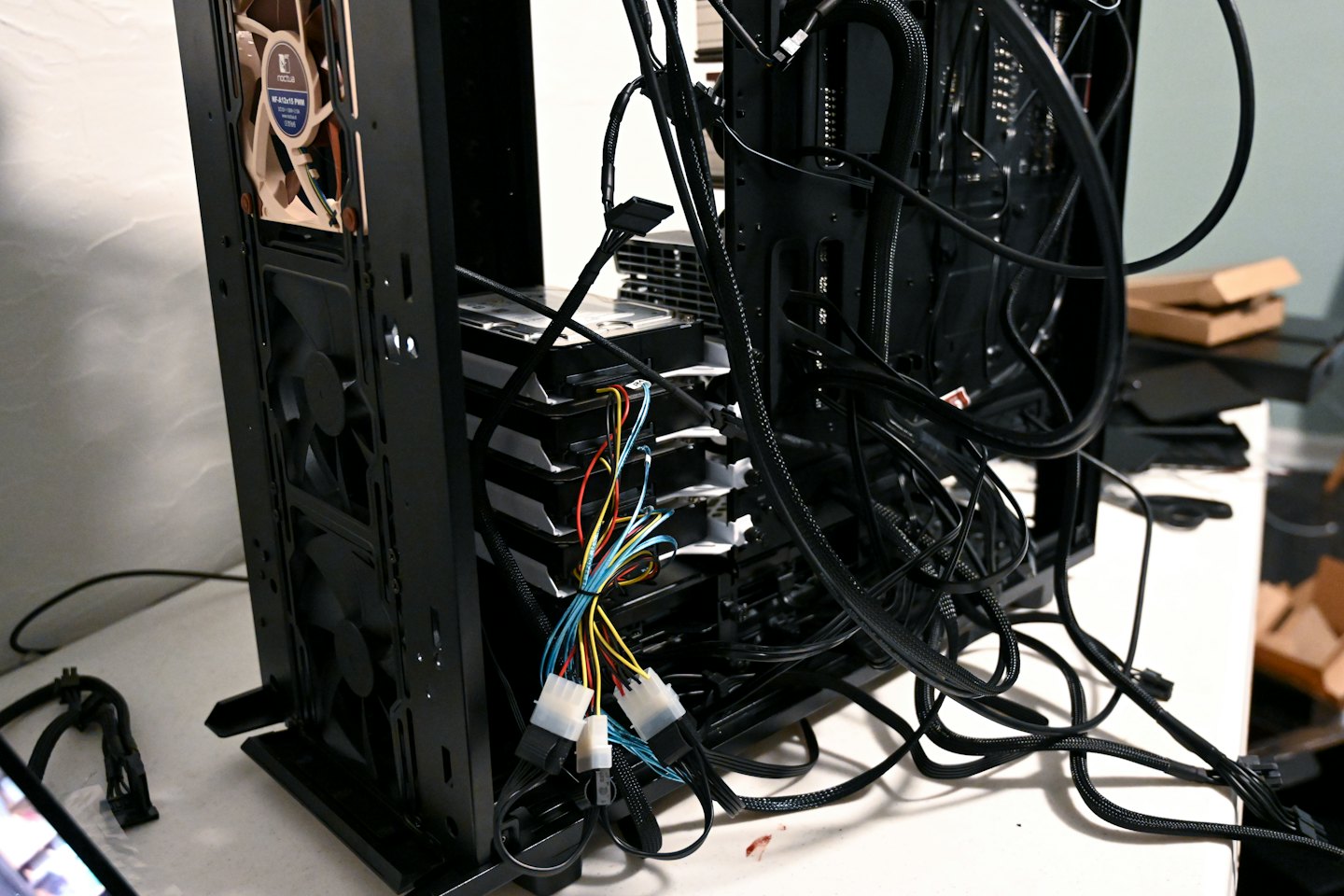 Computer server with stacked hard drives and tangled cables.